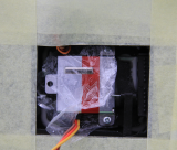 Zalepeny ramecek serva klapky. Tady je krasne videt zajisteni tahla v pace (zajistovaci "jehla" je tesne polozena na horni strane serva)